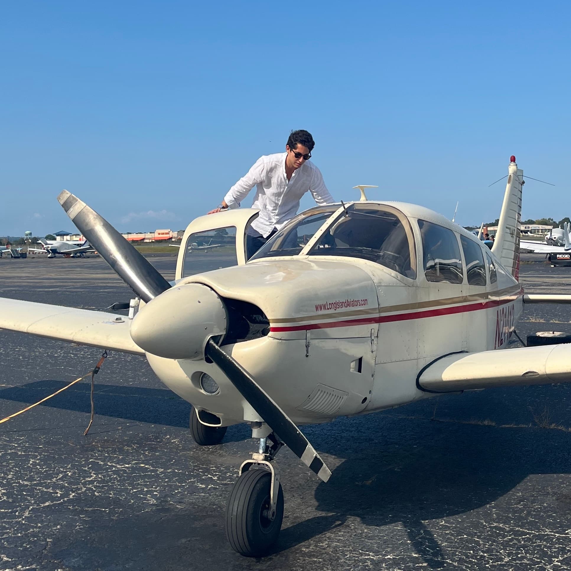 Diego Casabuena, founder of Lokos, leaning on a single-engine aircraft on an airfield